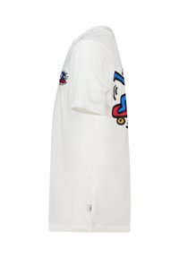 T-shirt blanc à manches courtes avec un design graphique comportant des accents bleus et rouges. Coupe décontractée, texture lisse et détail d'étiquette sur le côté.