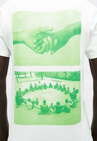 Δύο φωτογραφίες με πράσινη απόχρωση: στο πάνω μέρος, χέρια που αγγίζονται απαλά μεταξύ τους, και κάτω, ομάδα παιδιών που κάθονται σε κύκλο πάνω σε πλακόστρωτη επιφάνεια.