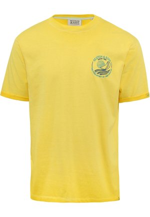 T-shirt jaune à manches courtes avec col rond et petit logo bleu de voilier ainsi que texte sur la poitrine gauche indiquant "Scotch & Soda Since 1985."