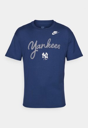 T-shirt en coton bleu marine avec le texte "Yankees" en police blanche incurvée et un petit logo blanc sur l'épaule gauche. Encolure ronde, manches courtes.