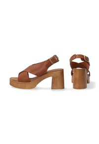 Braune Leder-Plateausandalen mit einem breiten Kreuzriemen-Design, verstellbarer Knöchel-Schnalle und einem klobigen Holzabsatz.
