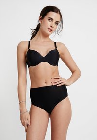 Black bra and high-waisted brief set. Smooth fabric, molded cups, adjustable straps, seamless design. Minimalist look with no patterns.
