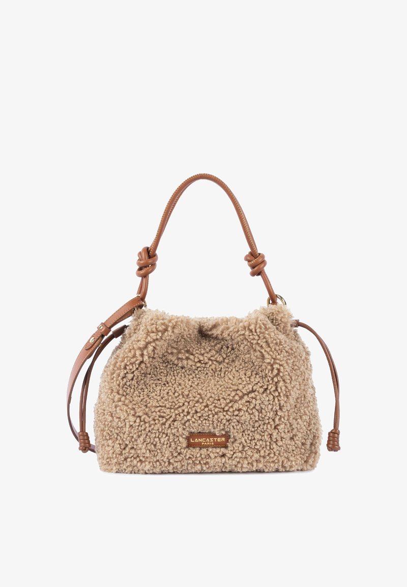 Sac à main beige en fausse peau d'agneau bouclée avec poignée en cuir beige et bandoulière réglable, avec une plaque siglée Lancaster Paris.