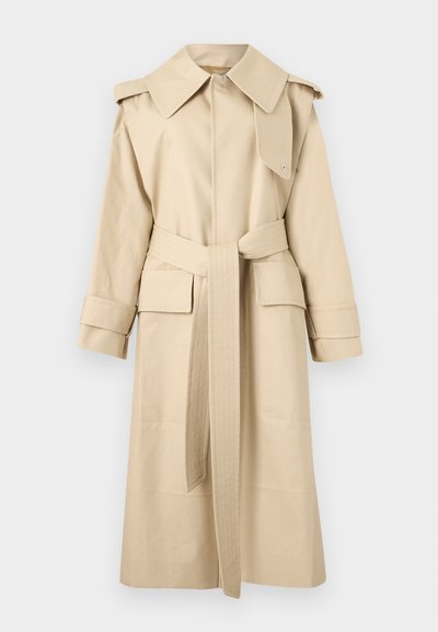Trench-coat long beige avec col large, taille ceinturée, poches à rabat, épaulettes et brides aux poignets.
