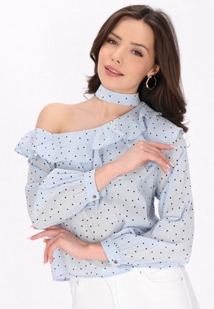 Lys blå off-shoulder bluse med sorte prikker, flæsedetaljer, lange ærmer, knappedage og matchende choker. Tekstureret stof.