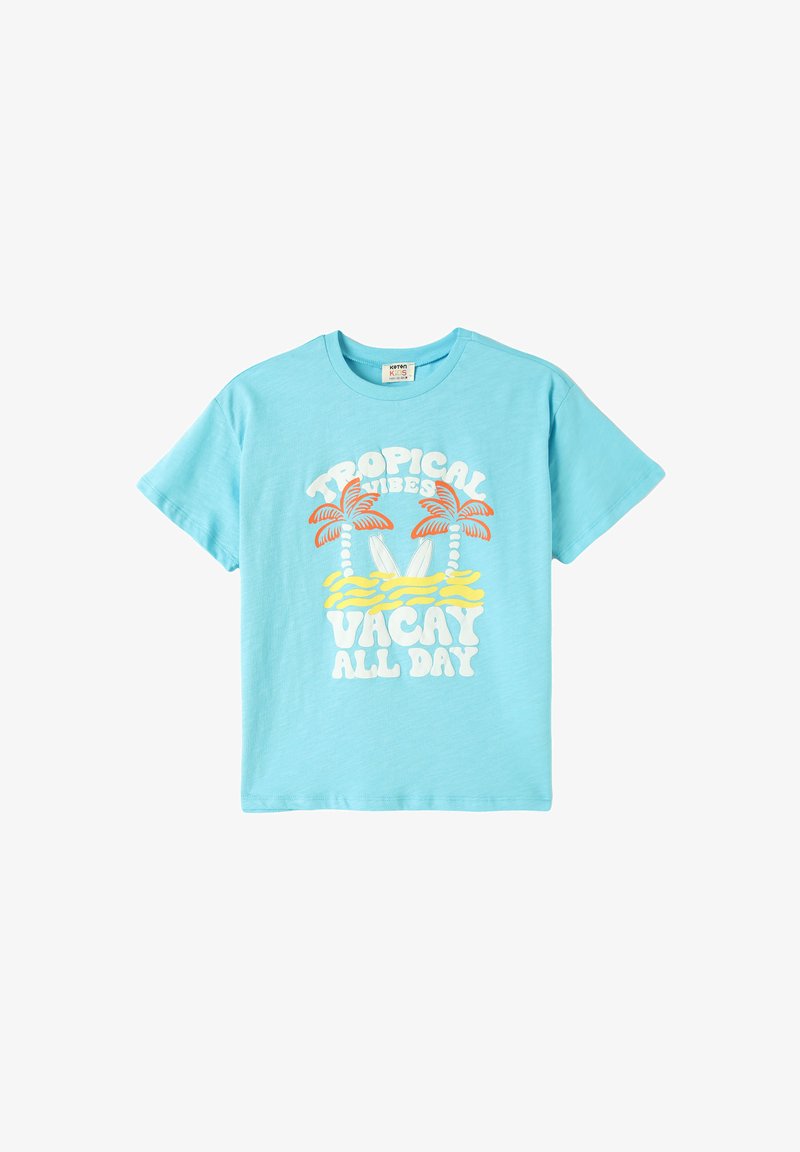 Camiseta de algodón azul claro con mangas cortas, que presenta un gráfico colorido de palmeras, tablas de surf y un texto que dice "Vibras Tropicales Vacaciones Todo el Día".
