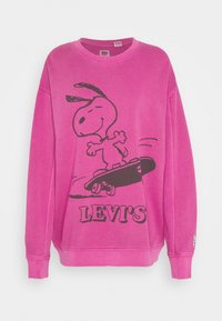 Pink sweatshirt med en sort Snoopy grafik på en skateboard og "LEVI'S" tekst. Den har lange ærmer og ribbet halsudskæring.