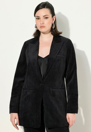 Blazer in velluto corduroy nero con colletto a revers, chiusura a un bottone, due tasche frontali e texture a coste verticali.