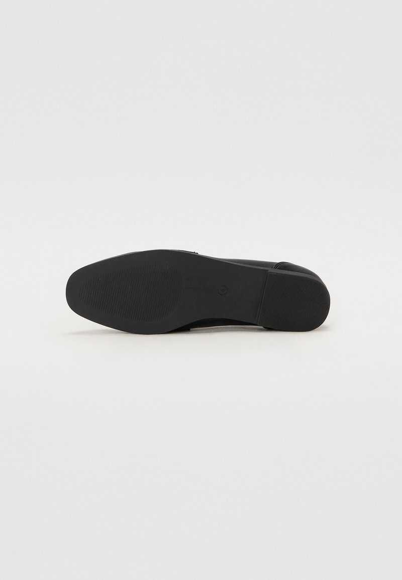 Sole di scarpa nera con superficie liscia e leggermente texture. Presenta una forma arrotondata e un design flessibile. Nessun motivo o accentuazione visibile.