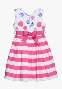 Vestido sin mangas para niñas con falda de rayas horizontales en rosa y blanco, parte superior blanca con estampados de conchas de mar en rosa y azul, y cinturón con lazo rosa en la cintura.