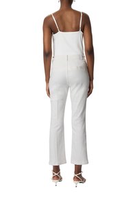 Białe spodnie szerokie w nogawkach z wysokim stanem, wykonane z mieszanki bawełny. Posiadają kieszenie z tyłu oraz dopasowany krój. Połączone z prostym białym topem.