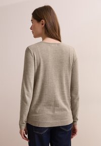 Maglione grigio chiaro a maniche lunghe con scollo rotondo. Realizzato in tessuto morbido, presenta polsini a coste e un orlo liscio.