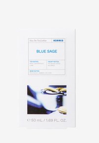 Eau de Toilette-förpackning i vitt med blå text. Framsidan visar "Blue Sage" och doftnoter. Inkluderar en liten, suddig bild av olja och örter.