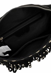 Borsa nera con borchie metalliche lungo il bordo. L'interno presenta una tasca con zip e una fodera in tessuto liscio. Chiusura con zip sulla parte superiore.