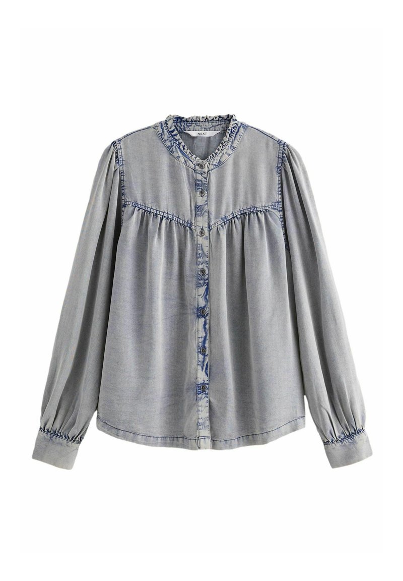 Lichtgrijze denim blouse met een knoopsluiting aan de voorkant, gathers op de schoudernaden en een gerimpelde kraag. Lange mouwen met elastische manchetten.