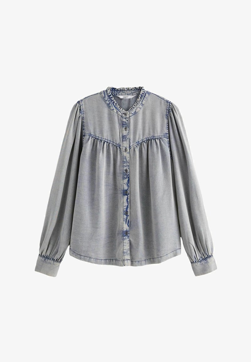 Lichtgrijze denim blouse met een knoopsluiting aan de voorkant, gathers op de schoudernaden en een gerimpelde kraag. Lange mouwen met elastische manchetten.