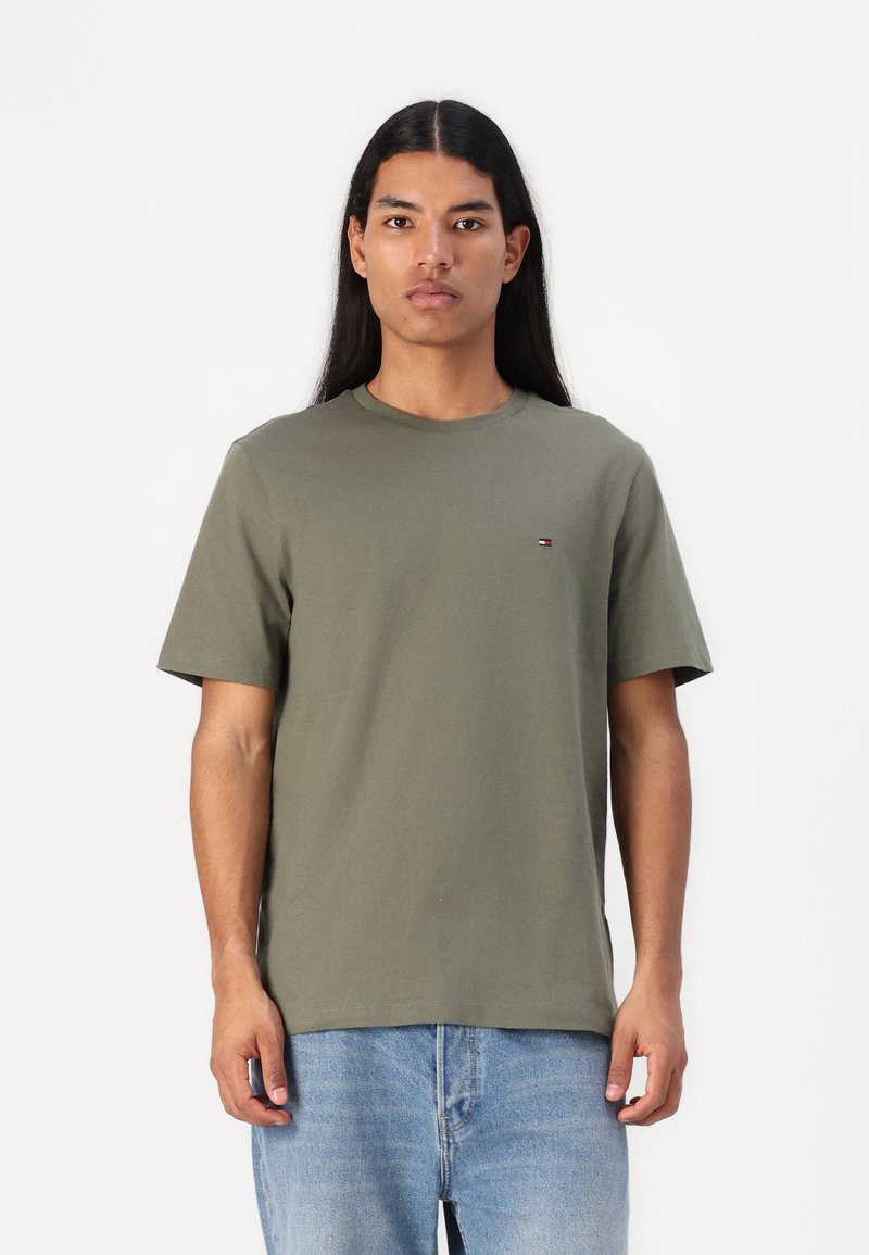 T-shirt in cotone verde oliva con colletto girocollo, maniche corte e un piccolo logo sul petto. Vestibilità casual e texture liscia.