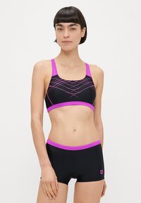 Μαύρο αθλητικό πάνω μέρος μαγιό με ροζ λεπτομέρειες, διακοσμημένο με γεωμετρικό σχέδιο και φαρδιές τιράντες. Συνδυάζεται με μαύρο μαγιό σορτς, επίσης με ροζ περιθώρια.