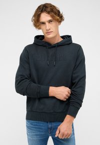 Tmavosivá mikina s kapucňou z bavlny s klokanie vreckom a rebrovanými manžetami. Má vyrazený nápis "MUSTANG" na prednej strane.