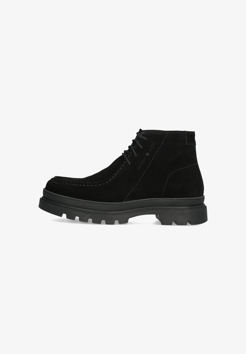 Stivaletto alla caviglia in suede nero con superficie testurizzata, cuciture a contrasto e suola in gomma resistente con un motivo a battistrada multidirezionale.