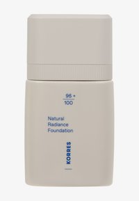 Botella cuadrada beige con una textura suave y un acabado mate. Presenta una tapa plana y rectangular y una etiqueta impresa en texto azul.