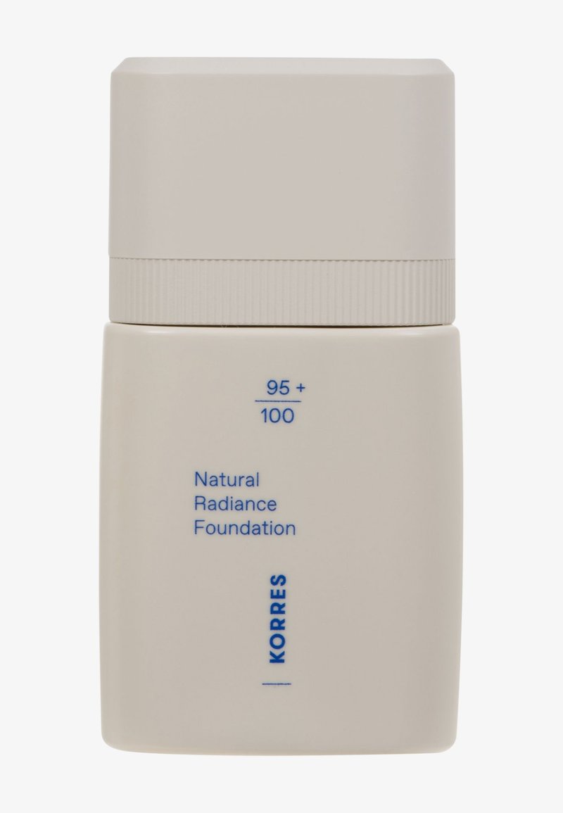 Botella cuadrada beige con una textura suave y un acabado mate. Presenta una tapa plana y rectangular y una etiqueta impresa en texto azul.