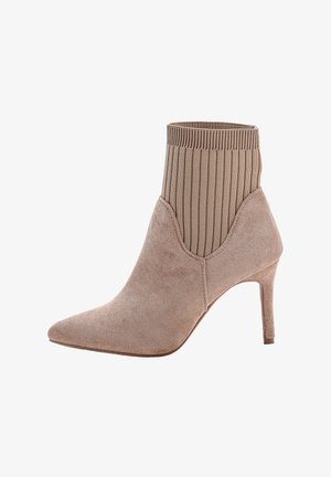 Beige suède enkellaars met puntige neus, ribbelgebreide sokachtige bovenkant en slanke hoge hak.
