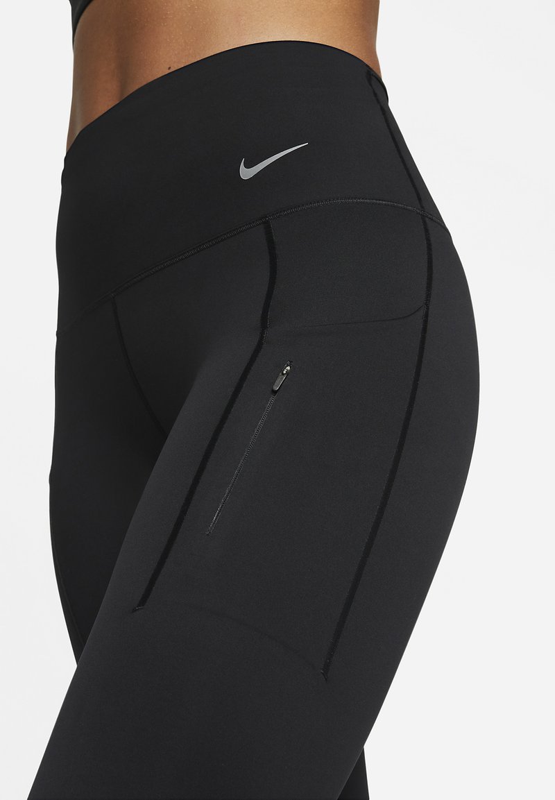 Zwarte sportleggings gemaakt van rekbare stof met een hoge tailleband, voorzien van een klein ritszakje en een reflecterend logo-detail.
