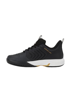 Chaussure de sport noire et blanche avec lacets à l'avant, côtés texturés et texte "ULTRASHOT LIGHT" en doré sur le côté.