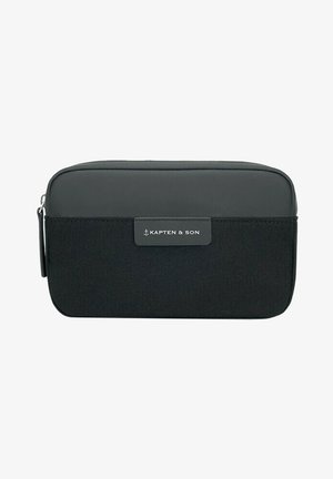 Pochette da viaggio nera in doppio materiale con parte superiore in tessuto sintetico liscio e parte inferiore in tessuto testurizzato, con una placca del logo sul davanti.