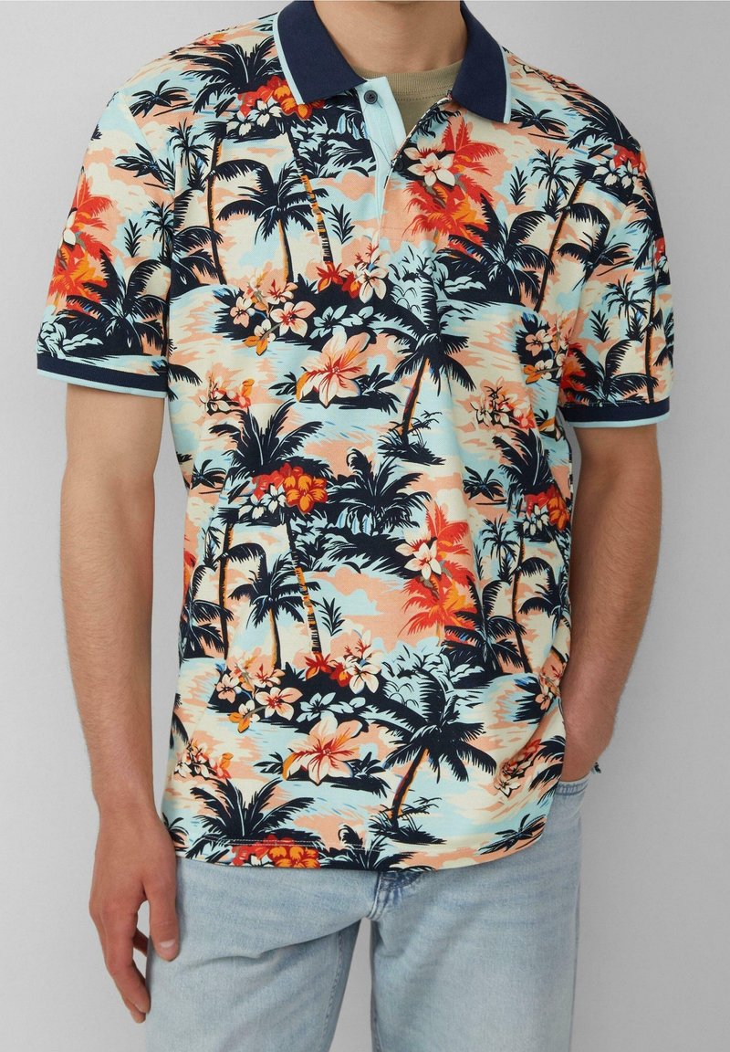 Polo à manches courtes avec un imprimé tropical mettant en avant des palmiers et des fleurs orange, rose et bleu sur un fond clair. Col marine.