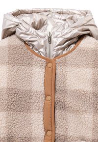 Beige en crèmekleurig fleecejack met een glanzende zilveren capuchon, voorzien van een ritssluiting en beige accenten, zachte textuur en grote knopen.