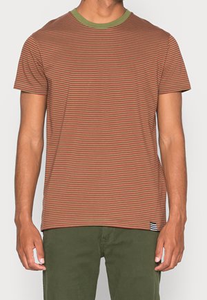 Homme portant un T-shirt à manches courtes rayé marron et orange avec un col rond vert et un pantalon vert olive.