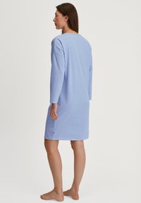 Abito a righe blu chiaro con maniche lunghe, taglio all'altezza del ginocchio e spacchi laterali. Realizzato in un tessuto morbido, presenta una vestibilità comoda e un collo semplice.