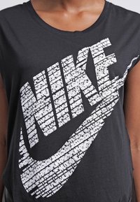 Svart T-shirt med vitt Nike-logotyp som är uppbyggd av upprepade små textrader som säger "Det finns ingen mållinje."
