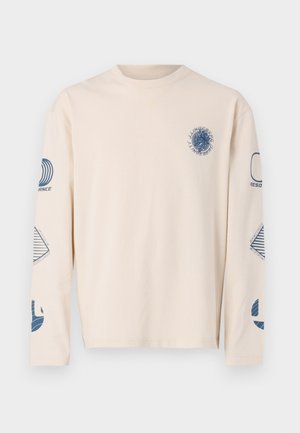 Long-sleeve, beige T-shirt made of cotton. Features blue graphic prints on the chest and sleeves, with various geometric designs.
