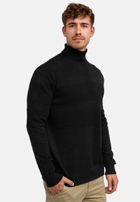 Maglione a collo alto nero lavorato a maglia con strisce testurizzate, maniche lunghe e design aderente. Tessuto liscio e caldo con polsini a coste.