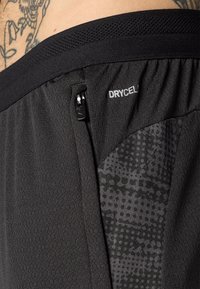 Μαύρα αθλητικά σορτς με υφή, πλεκτή ζώνη, πλευρική τσέπη με φερμουάρ και μοτίβο με λογότυπο DYNAMIC.