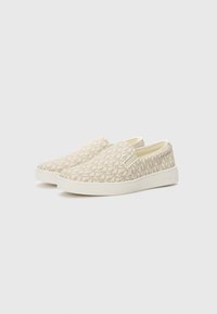 Chaussures slip-on en toile beige avec un motif subtil. Dotées d'une semelle en caoutchouc blanc et de panneaux élastiques sur les côtés pour un enfilage facile.