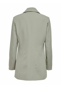 Blazer gris clair avec une coupe ajustée, col cranté et manches longues. Sa texture lisse et son design minimaliste améliorent sa fonctionnalité.