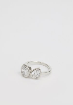 Silver ring featuring two pear-shaped, clear stones set in polished bezels, highlighting a smooth band with a minimalist design.