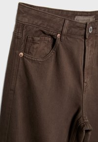 Bruine denim broek met een gladde textuur, voorzien van koperen klinknagels, een klassieke vijf-pocketdesign en een rechte pasvorm.