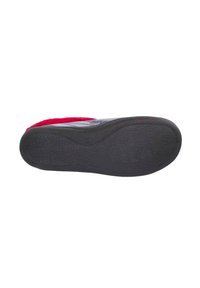 Suela de goma negra con superficie texturizada, con un detalle prominente de logo y forma redondeada. Parte superior en tela roja y gris.