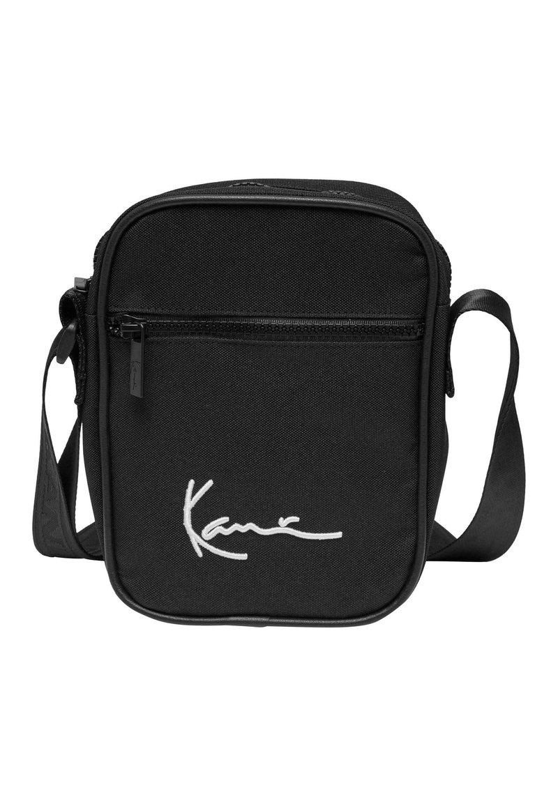 Borsa a tracolla nera realizzata in tessuto resistente, dotata di una tasca frontale con zip e logo distintivo bianco. Cinghia regolabile per maggiore comodità.