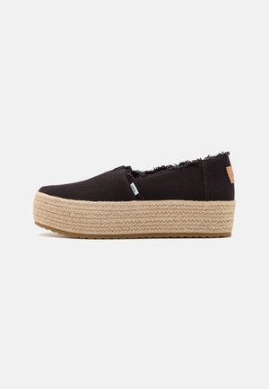 Chaussures à enfiler en toile noire avec une semelle intermédiaire en jute tressé et une semelle extérieure en caoutchouc texturé. Bord supérieur effiloché et détail discret avec étiquette logo.