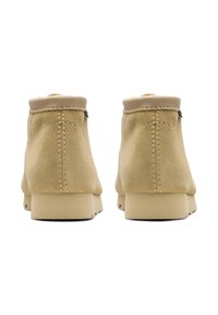 Beige ruskindsankeleder med rund tå, glat overkant og minimale syninger. Kraftige gummisåler.