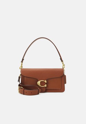 Brown leather handbag with gold clasp shaped like a "C," featuring a top handle and an adjustable shoulder strap against a white background.