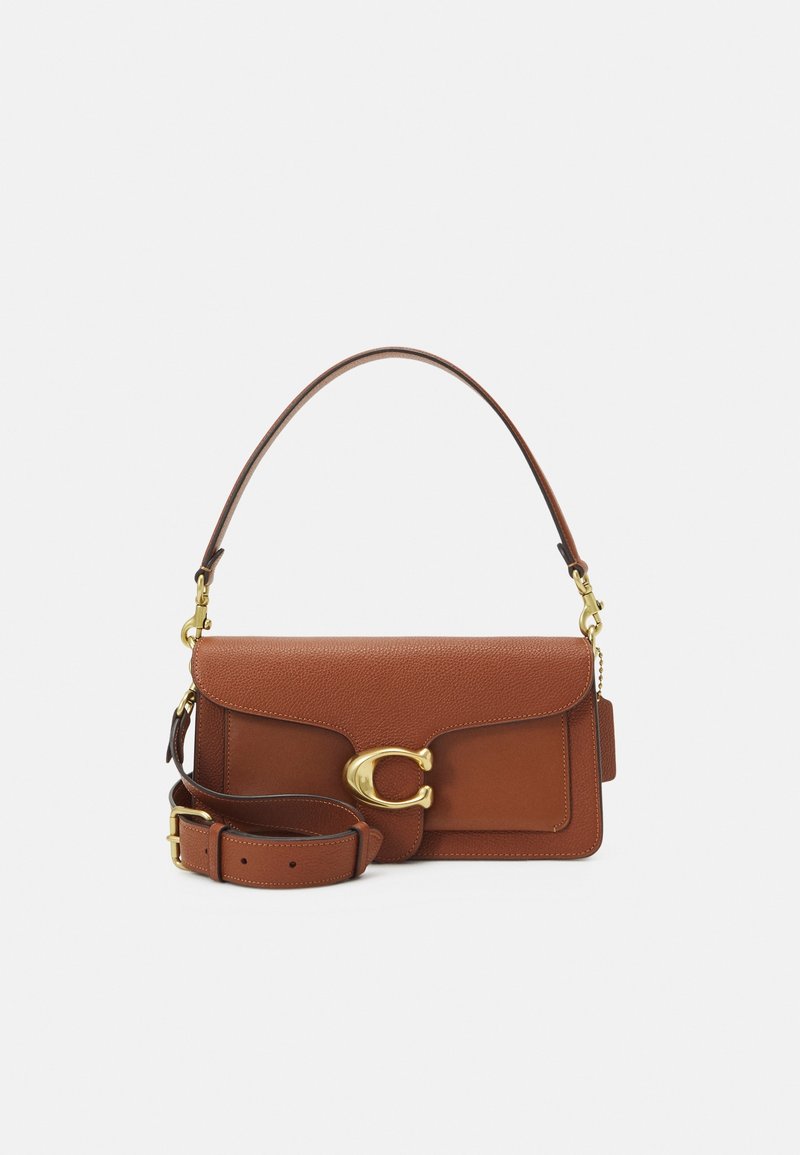 Sac à main en cuir marron avec une fermeture en or en forme de "C", équipé d'une poignée supérieure et d'une bandoulière réglable sur un fond blanc.