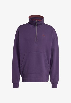 Purple fleece pullover with a half-zip collar, front pocket, ribbed cuffs, and a logo emblem on the chest. Soft texture and relaxed fit.