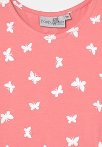 Růžové tričko vyrobené z měkké látky, zdobené opakujícím se vzorem bílých motýlů. Kulatý výstřih a krátké rukávy. Na štítku je nápis "šťastné dívky."